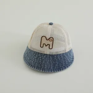 Detail of mesh baby sun hat featuring denim brim and embroidered smile face M patch