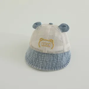 Détail du chapeau bébé montrant le mesh respirant et la broderie ours en denim bleu