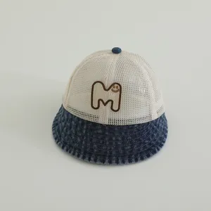 Detail of baby sun hat with breathable mesh top and smiley face embroidery on denim brim