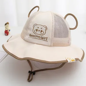 Detail van baby zonnehoed met mesh panelen, beer borduursel en verstelbaar windkoord