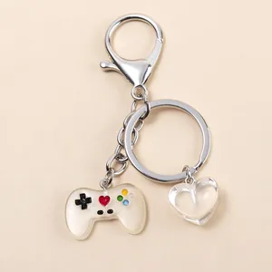 Detalle del llavero de mando de consola con gamepad de resina y colgante de corazón