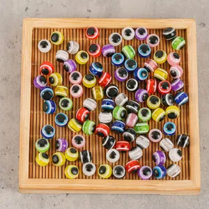 Perles mauvais oeil colorées de 8mm en résine pour bijoux DIY sur un plateau en bois