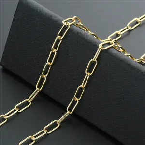 Macro view of polished gold paperclip chain link on a textured jewelry display