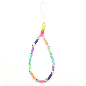 Macro view of colorful evil eye beads and polymer clay slices on a bohemian phone strap