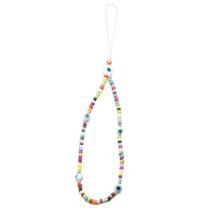 Detail of colorful beads and blue evil eye charms on a bohemian style phone strap