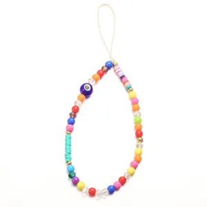 Macro detail of colorful clay and bead phone lanyard featuring a blue evil eye charm