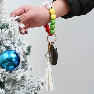Close-up of Christmas wooden beads wristlet keychain with leather tassel on wrist