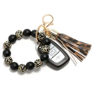 Detail of leopard print silicone bead keychain with leather tassel and gold clasp
