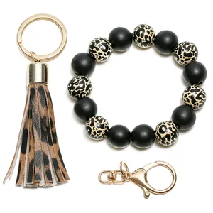 Detail view of leopard print silicone beads keychain with stylish leather tassel and gold ring