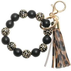 Detail of leopard print silicone beads and faux leather tassel on bracelet keychain