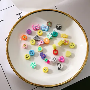 Makroaufnahme bunter Fimo-Perlen mit Smileys und Tieren in einer weißen Schale