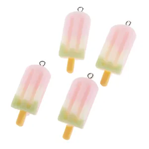 Primer plano de cuatro colgantes de resina de helado tricolor con aros metálicos