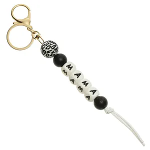 Detail of beaded keychain with leopard print, black beads, MAMA letters and white tassel