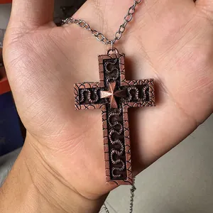 Detailed macro of vintage bronze cross pendant with intricate snake texture and star emblem