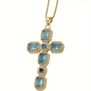 Macro detail of a gold cross pendant with blue zircon stones and white crystals
