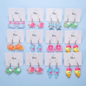 Detail view of colorful acrylic earring set featuring cartoon crab, fish and bear charms