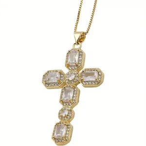 Detailed close-up of gold cross pendant with rectangular and round clear zircon stones