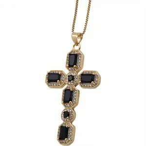 Macro detail of gold cross pendant with black gemstones and micro-pave zircon crystals