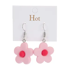 Detail of pink floral drop earrings on display card with matte resin flower petals