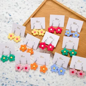 Macro shot of colorful matte acrylic flower earrings on display cards for women