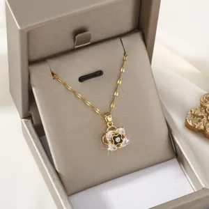 Detail of rotating crystal clover necklace in a premium gold gift box with white silk