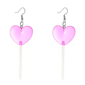 Macro view of cute pink heart-shaped lollipop earrings with creative acrylic finish