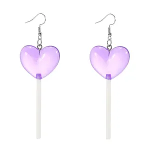 Macro view of purple heart-shaped lollipop drop earrings with silver metal hooks