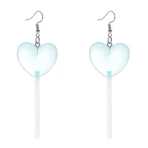 Close-up of heart-shaped blue lollipop earrings with silver hooks on white background