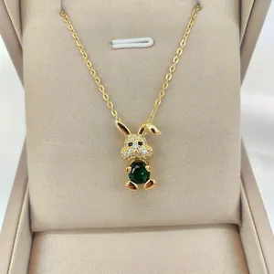 Detail of 14K gold plated rabbit pendant featuring a large green stone and micro-pave crystals