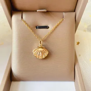 Close-up of a golden shell pendant necklace with sparkling zircons in a jewelry gift box