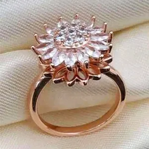 Macro detail of rotating sunflower ring with rose gold petals and zircon inlay