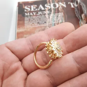 Detail of rotating sunflower ring in gold finish with micro-set white zircon stones