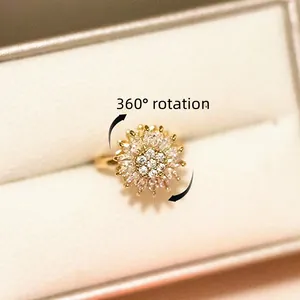 Rotating sunflower open ring with cubic zirconia center on a white jewelry box