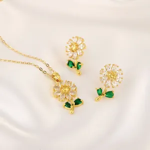 Detail view of sunflower jewelry set with emerald green leaves on white silk