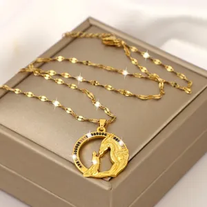Collana dorata con ciondolo drago e principessa e zirconi su una confezione regalo di lusso