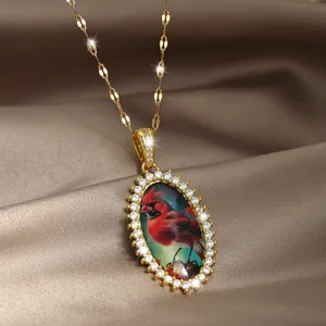 Elegante collana dorata con ciondolo uccellino rosso e pavé di zirconi brillanti