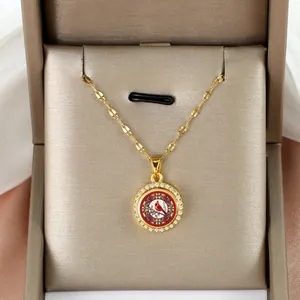 Macro shot of gold cardinal bird necklace pendant with shimmering zircon pavé border