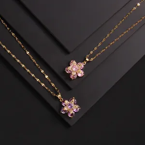 Macro detail of copper flower pendant with heart-shaped purple crystals and zircon accents