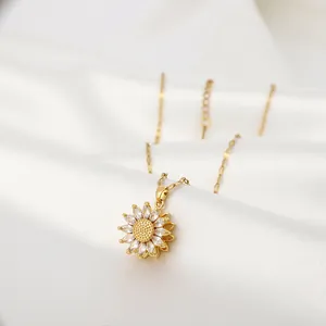 Dettaglio macro del ciondolo a girasole con petali in zircone e finitura dorata