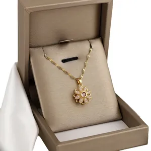Gouden zonnebloem ketting met roze kristal in een luxe geschenkdoos met wit zijde