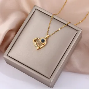 Dettaglio collana a cuore MOM dorata con zirconi e pietra di proiezione su astuccio