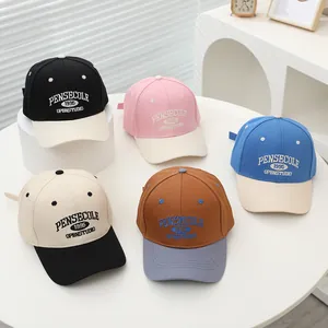 Detail of vintage embroidered letters on multi-color patchwork children baseball caps