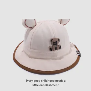 Détail du chapeau bébé avec oreilles 3D et patch ours en silicone sur coton crème