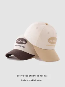 Close-up of contrast brim baseball caps for kids with creative oval embroidery