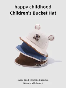 Détail de trois chapeaux bob pour bébés empilés avec broderie ours et oreilles