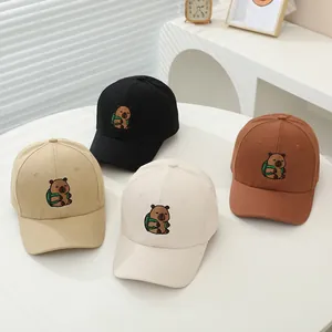Detalle del bordado de carpincho en gorras de algodón en cuatro colores neutros