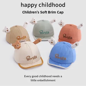 Detail view of cotton baby hats in five colors with cute bear dolls and Smile embroidery