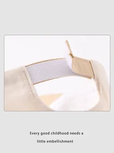 Detail of adjustable velcro strap on cream cotton baseball cap for children