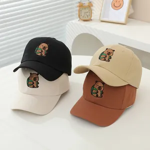 Detalle de cuatro gorras de béisbol infantiles con bordado de un simpático carpincho