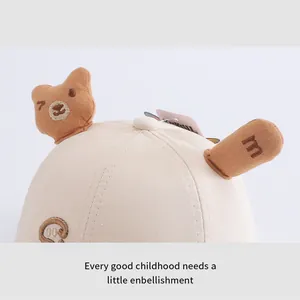 Close-up of baby baseball cap with plush bear ears and fine embroidery details